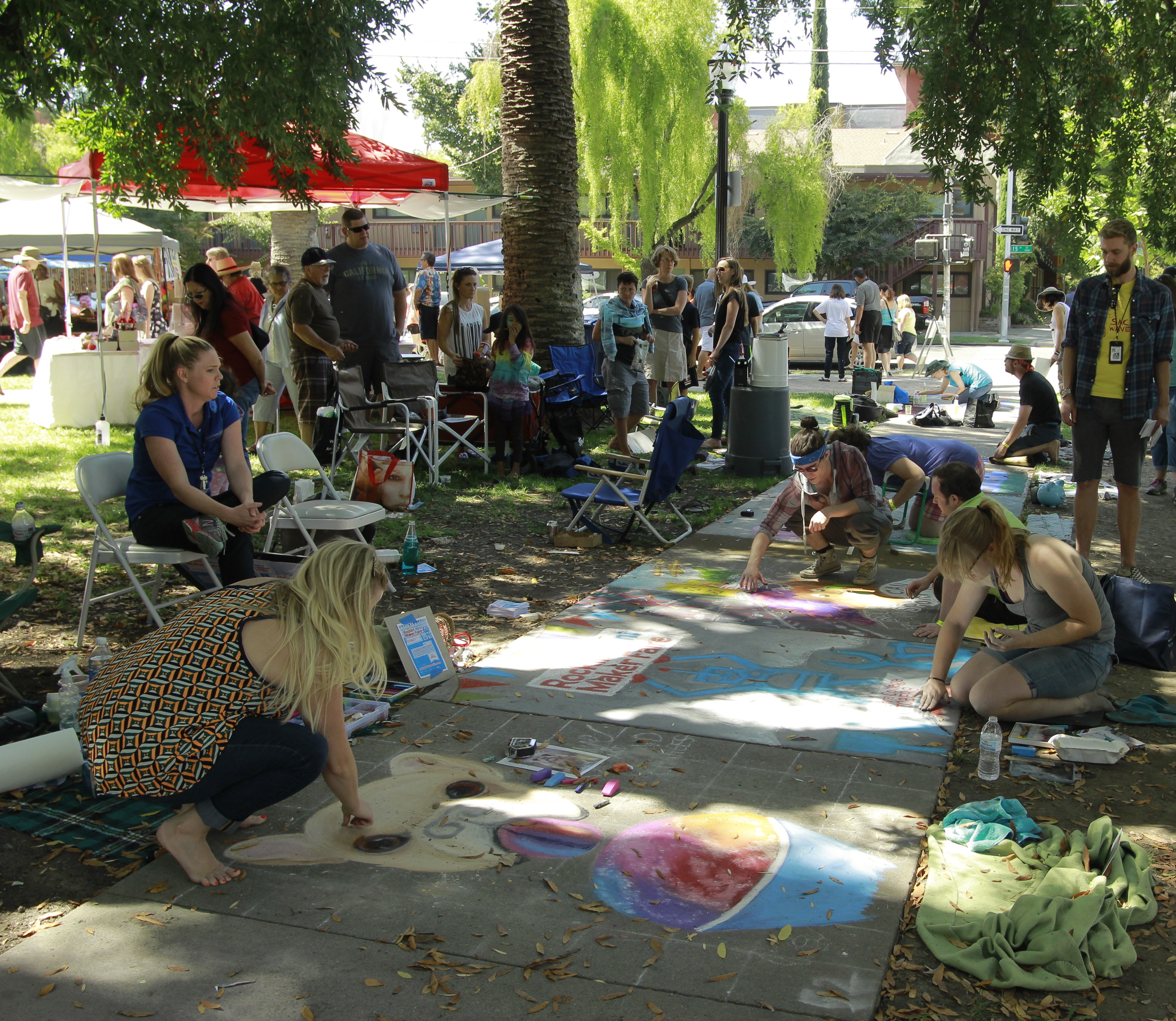 an image of people drawing with chalk on sidewalk
