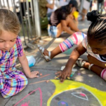 kids drawing with chalk on sidewalk