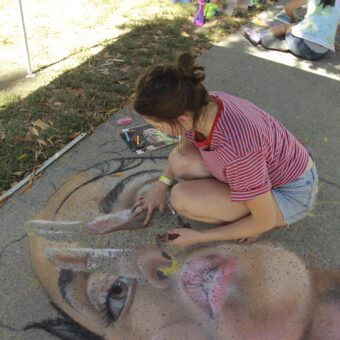 image of person making chalk art on sidewalk